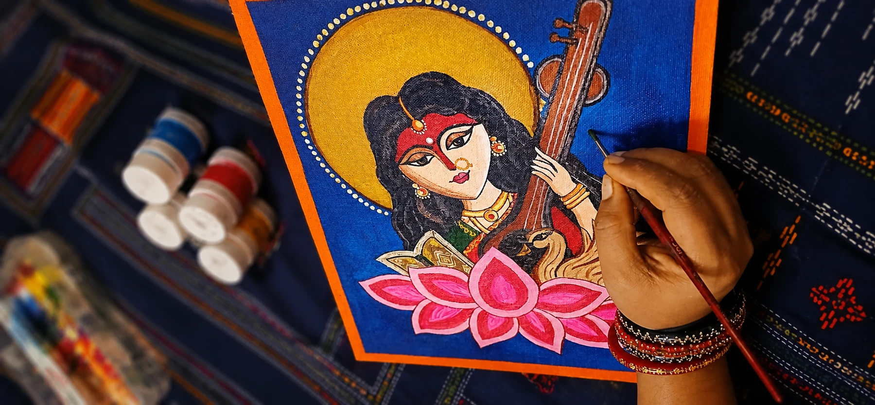 Artist hand-painting an original Mithila artwork